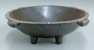 A Pacific Islands carved hardwood Kava bowl on four short legs,