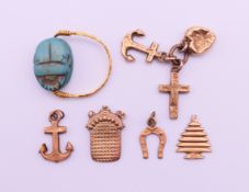 Seven gold charms (two anchors, a cross, a heart, a Christmas tree, a horseshoe, and a purse),