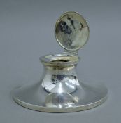 A silver capstan inkwell. 14 cm diameter.