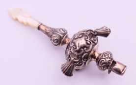 A silver and mother-of-pearl baby rattle and whistle. 10 cm high.