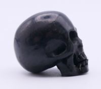 A small carved skull. 3 cm high.