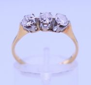 An 18 ct gold and platinum three-stone diamond ring. Ring size N/O. 2.2 grammes total weight.