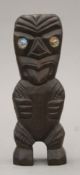 A Maori carved wooden Tiki statue with abalone-set eyes. 17.5 cm high.