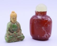 A small carved jade Buddha and a Chinese snuff bottle with stopper.
