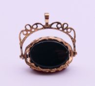 A 9 ct gold mounted triple sided bloodstone, carnelian and onyx swivel fob. 2 cm high, 2.2 cm wide.