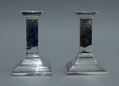 A pair of square section silver candlesticks. 12.5 cm high.