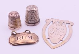 A silver bookmark formed as an owl, a silver 'RUM' decanter label and two silver thimbles.