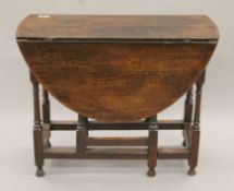 An early 20th century oak drop leaf table. 90 cm long.