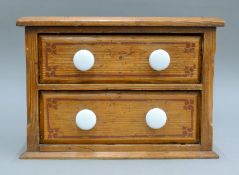A Victorian pitch pine two-drawer chest. 32 cm wide.