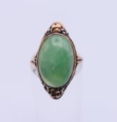 An unmarked gold and oval jade ring. Jade approximately 1.7 x 1.2 cm, ring size M/N. 4.