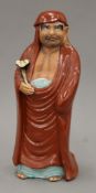 A late 19th/early 20th century Japanese Kutani ceramic figure of Daruma. 31.5 cm high.