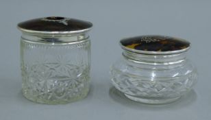 Two silver and tortoiseshell lidded glass dressing table jars. The largest 8.5 cm high.