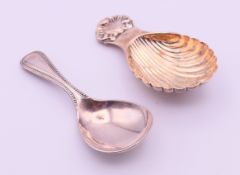 A silver caddy spoon and a silver plated caddy spoon. 8 cm long and 8.7 cm long respectively.