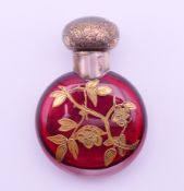 A Victorian silver topped red glass scent bottle and stopper with gilt floral overlay,