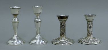 Two pairs of small silver candlesticks. The larger pair 13 cm high.