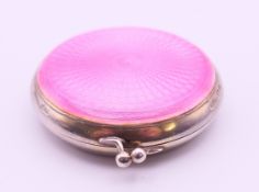 A rose pink guilloche enamel and silver compact. 5.3 cm diameter. 57.8 grammes total weight.