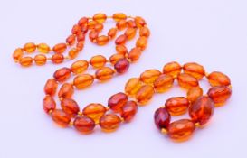 An amber type graduated bead necklace. 76 cm long, central bead 2.2 x 1.5 cm.