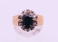 A 9 ct gold, sapphire and diamond cluster ring. Ring size N. 4.8 grammes total weight.