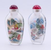 A pair of Chinese reverse-painted glass snuff bottles and stoppers. Each 8 cm high.