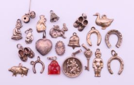 Twenty silver and white metal charms (horseshoes, duck, bells, hare, pig, key,