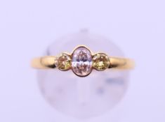 An 18 ct gold yellow and pink diamond three-stone ring. Ring size O/P. 2.8 grammes total weight.