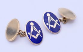 A pair of 9 ct gold and enamel Freemasons' cufflinks. 1.8 cm high. 7 grammes total weight.