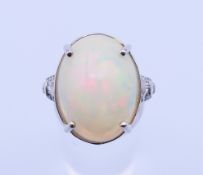A platinum, large cabochon opal and diamond ring. Opal approximately 2 x 1.5 cm, ring size O/P. 10.