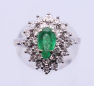 An 18 ct white gold, diamond and emerald ring. Ring size N. 6 grammes total weight.