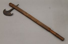 A Southern African Mashona axe with iron blade and wood shaft carved with zigzag designs.