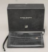A boxed Dunhill gentlemen's leather wrist bag. 28 cm wide.