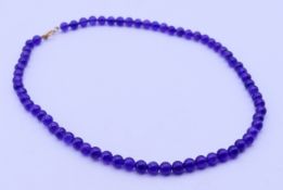 An amethyst bead necklace with a 9 ct gold clasp. 40 cm long.