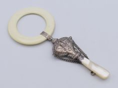 A silver and mother-of-pearl baby rattle and teething ring. 13.5 cm high.