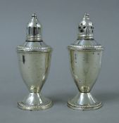 A pair of sterling silver clad salt and pepper pots. Each 11.5 cm high.