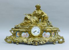A 19th century porcelain-mounted gilt bronze figural mantle clock. 63 cm wide.