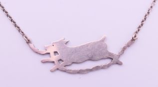 A silver running dog with string of sausages pendant necklace.