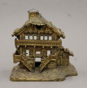 A 19th century bronze burner formed as an alpine cottage. 15 cm high.