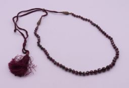A garnet bead adjustable necklace. Maximum length 90 cm, minimum 46 cm long.