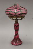 An Art Nouveau glass table lamp, the pink ground with bands of green decoration,