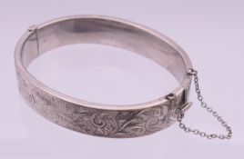 A silver bangle. 13 mm high, 6 cm internal diameter.