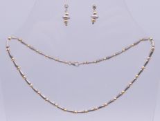 A silver and rolled gold necklace with matching earrings. Necklace 42 cm long, earrings 2 cm high.