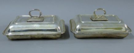 A pair of silver entree dishes, each engraved with a crest. Each 28 cm long. 127.7 troy ounces.