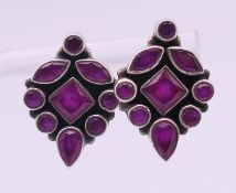 A pair of silver and ruby earrings. 22 mm high.