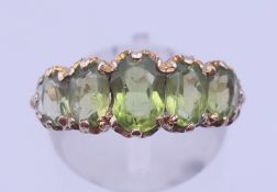 A 9 ct gold and peridot 5 stone ring. Ring size P. 3.9 grammes total weight.