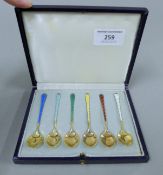 A cased set of Danish silver gilt and enamel coffee spoons. The case 15 cm wide. 46.