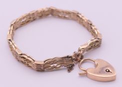 A 9 ct gold bracelet with padlock fastening. 19 cm long, 7 mm high. 15.7 grammes.