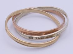 A 9 ct tri-colour gold Tiffany & Co interlocking three band bangle bracelet. 6.