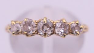 An 18 ct gold and five-stone diamond ring. Ring size M/N. 2.9 grammes total weight.