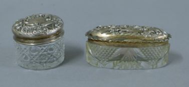 Two silver lidded glass dressing table jars. The larger 8 cm wide. 16.5 grammes.