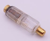 An unmarked gold-mounted double-ended glass scent bottle. 9 cm high.