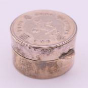 A silver trinket box with Hong Kong one dollar coin-set lid. 3 cm diameter.